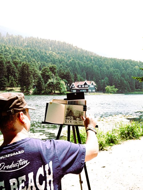 Free Artist sketching scenic view of Gölcük Lake in Bolu, Türkiye. Captivating summer landscape. Stock Photo