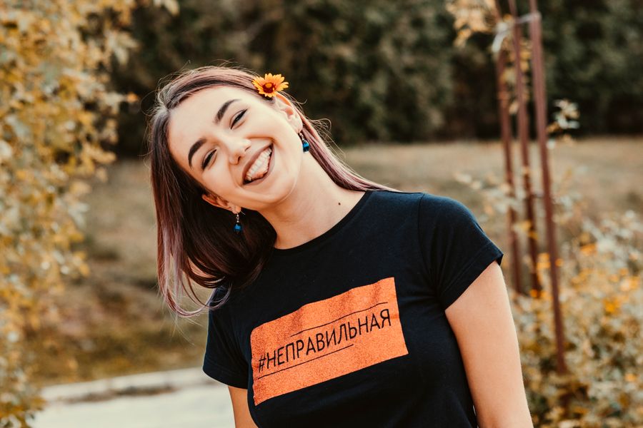 Smiling woman wearing a black tee outdoors