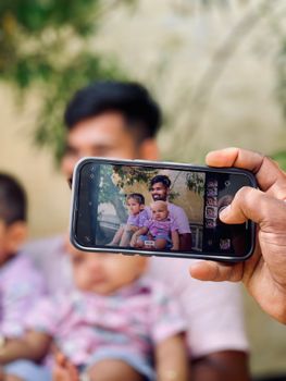 A family enjoying outdoor fun, captured through a smartphone in a summer setting.