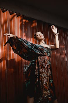 一位美丽的亚洲女子身着彩色连衣裙，在戏剧性的灯光下优雅摆姿，画面风格充满活力