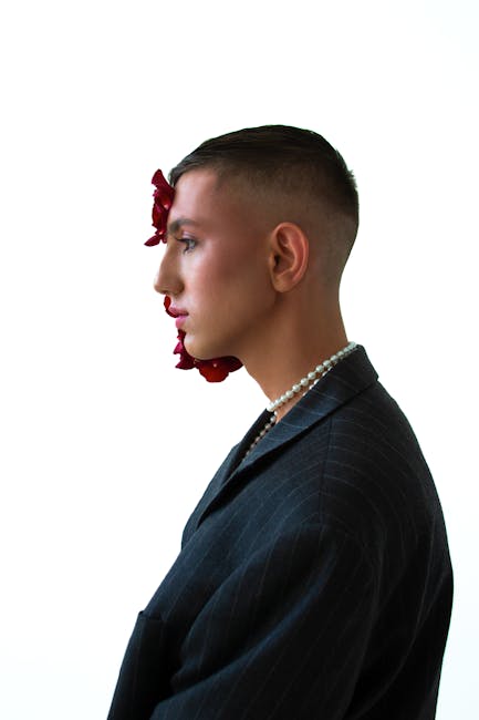 Elegant side profile portrait of a man adorned with pearls and red flowers, showcasing unique fashion style.