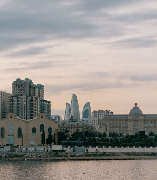 Free Scenic urban view of Baku's skyline with iconic Flame Towers and waterfront at dusk. Stock Photo