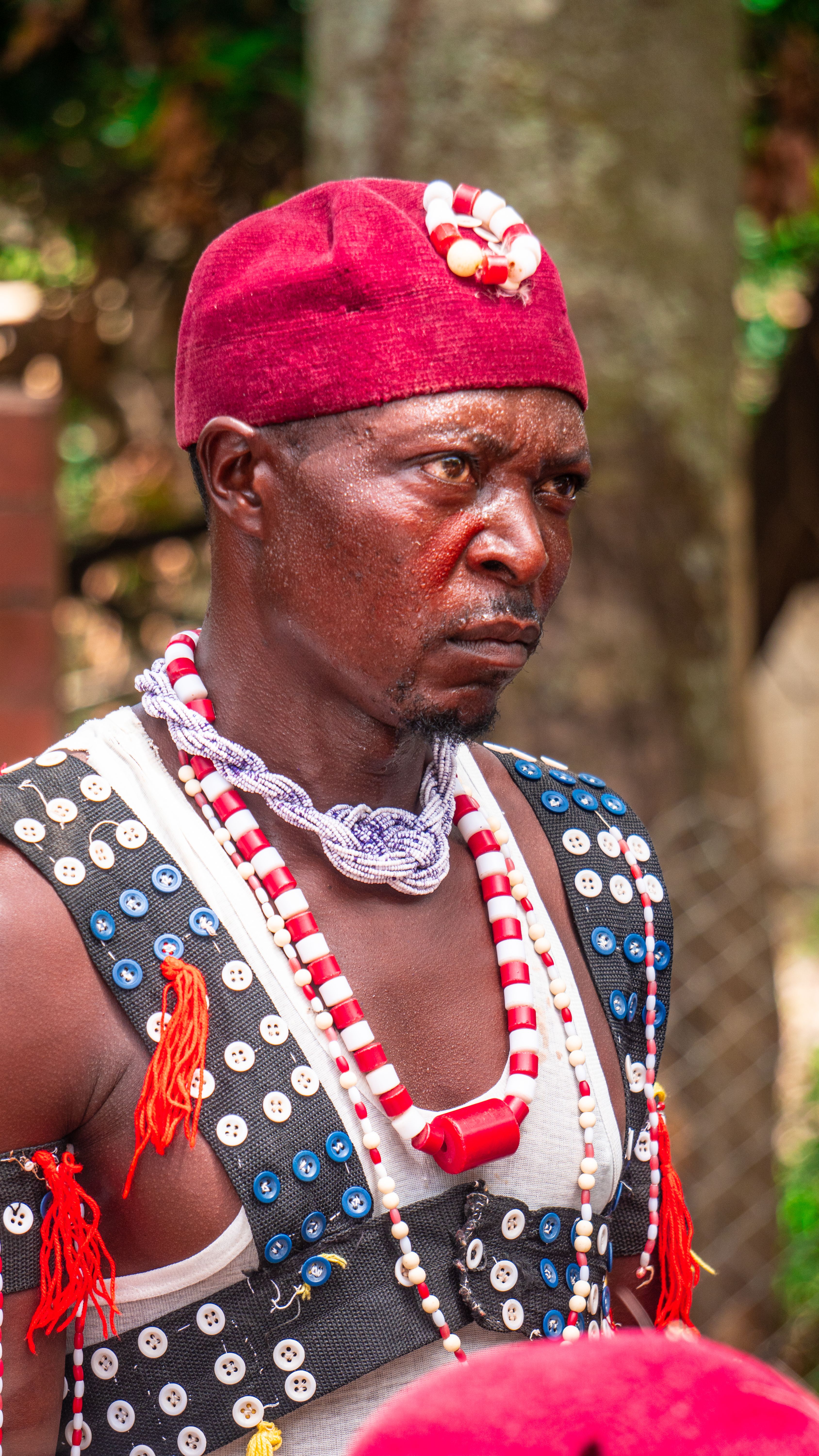 A man in a red and white outfit with beads · Free Stock Photo