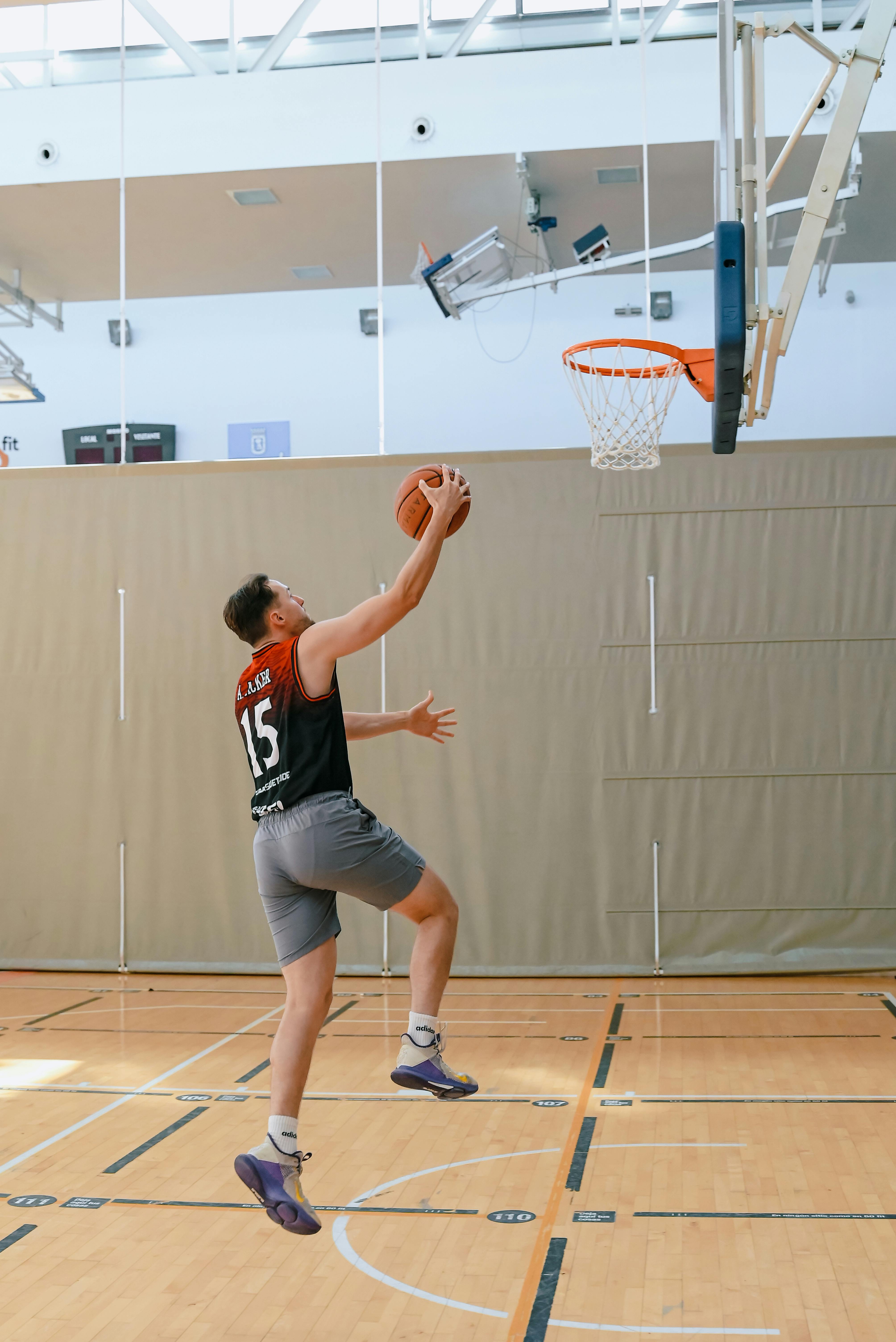 a man in black shorts is jumping to dunk a basketball