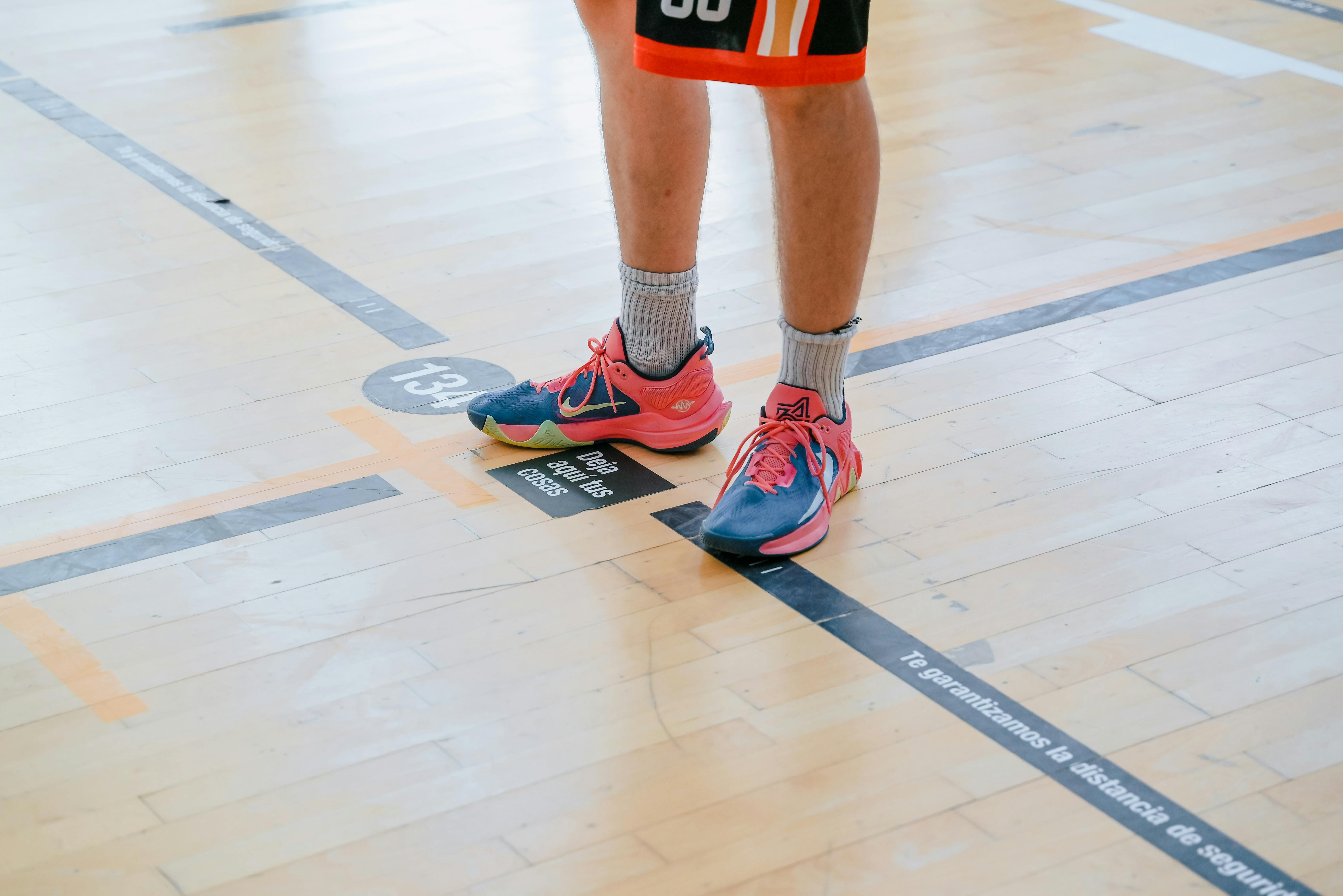 a person standing on a basketball court with their feet