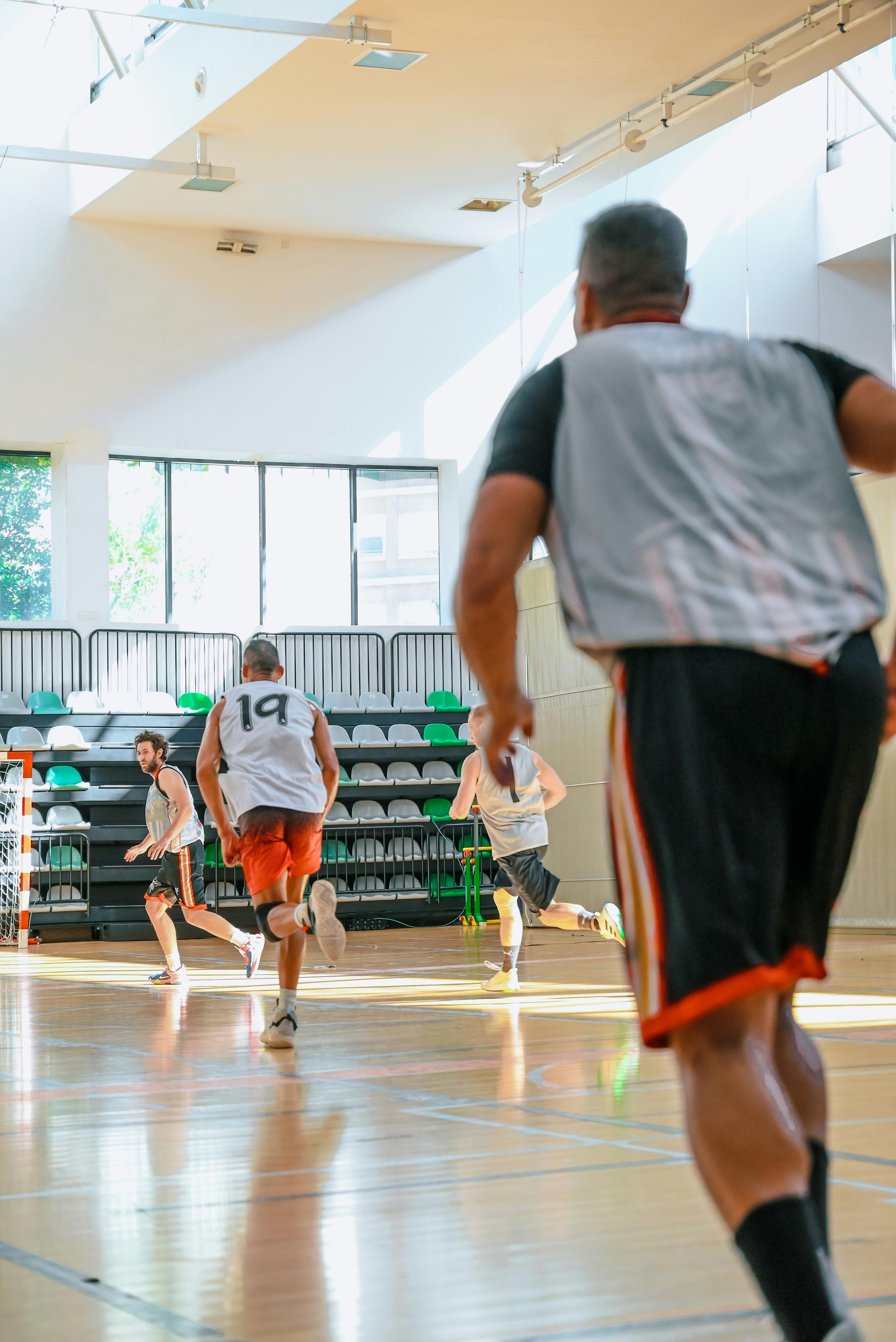 a group of men playing basketball in an indoor gym