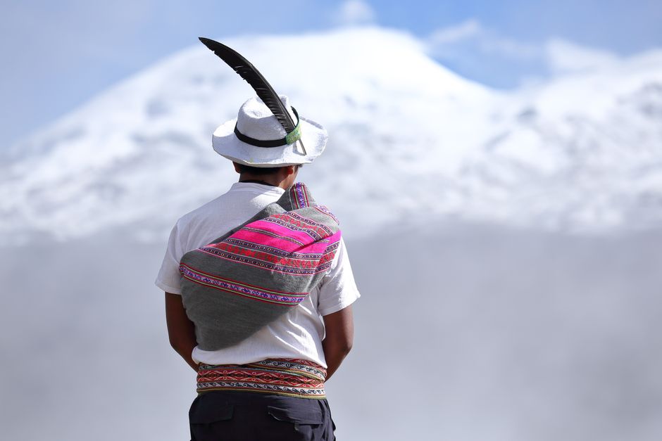 A person wearing traditional attire with a scenic snow-covered backdrop in Arequipa, Peru.