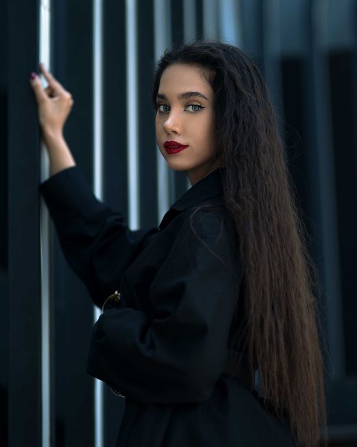 Stylish portrait of a woman with long hair in studio lighting.