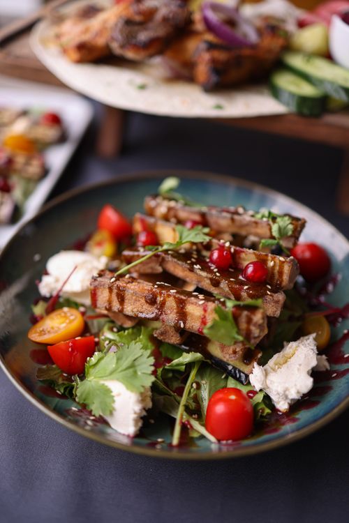 Free A delicious grilled meat dish garnished with fresh vegetables and herbs. Stock Photo
