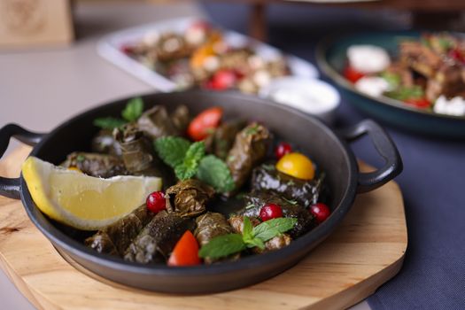 Delicious traditional dolma served with fresh garnish and lemon in a rustic setting.