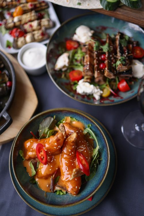 Free Delicious spicy chicken dish garnished with fresh vegetables, perfect for dinner. Stock Photo