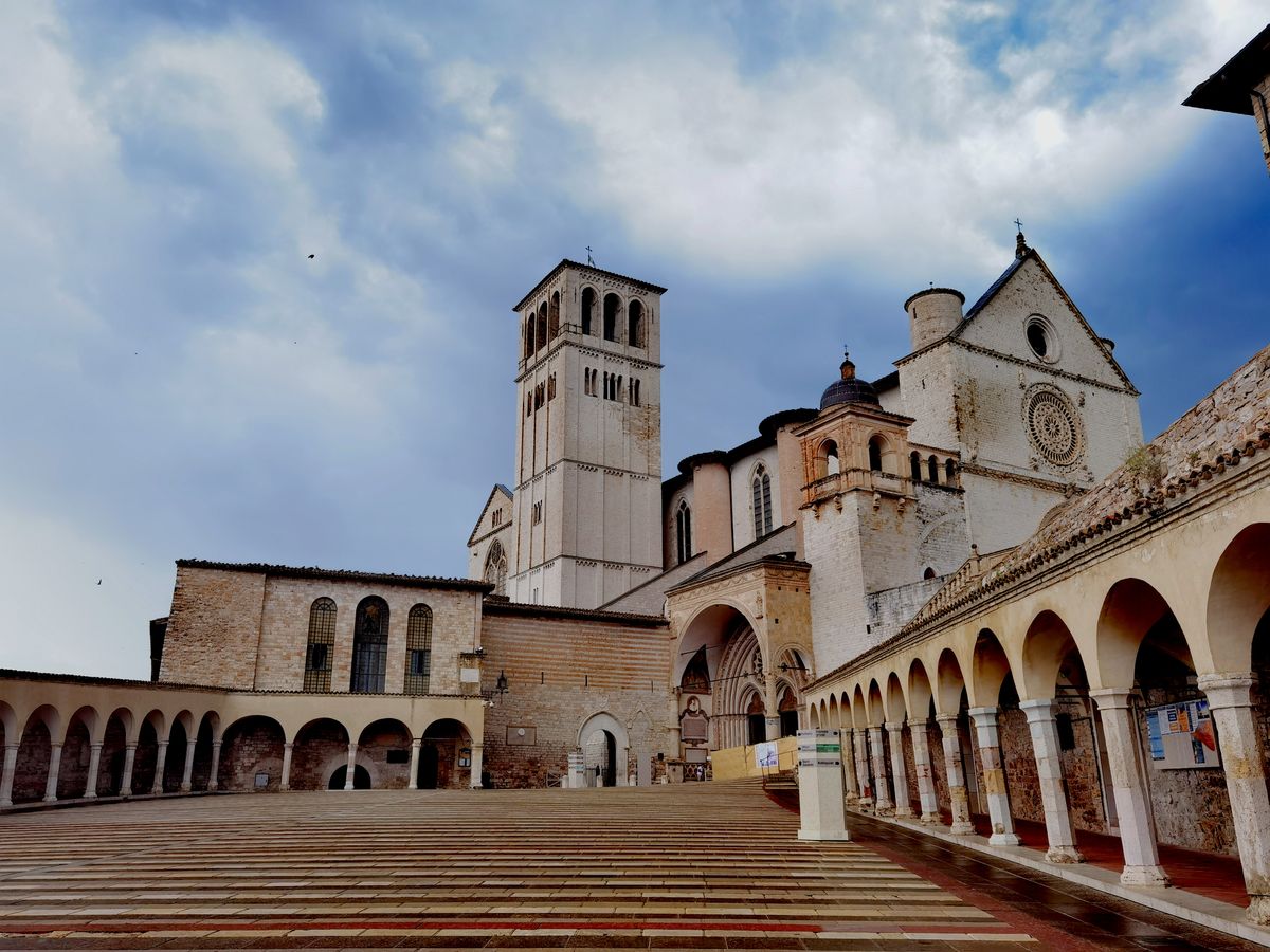 Flanc lateral de bazilica cu clopotnita si arcade, sub nori dramatici