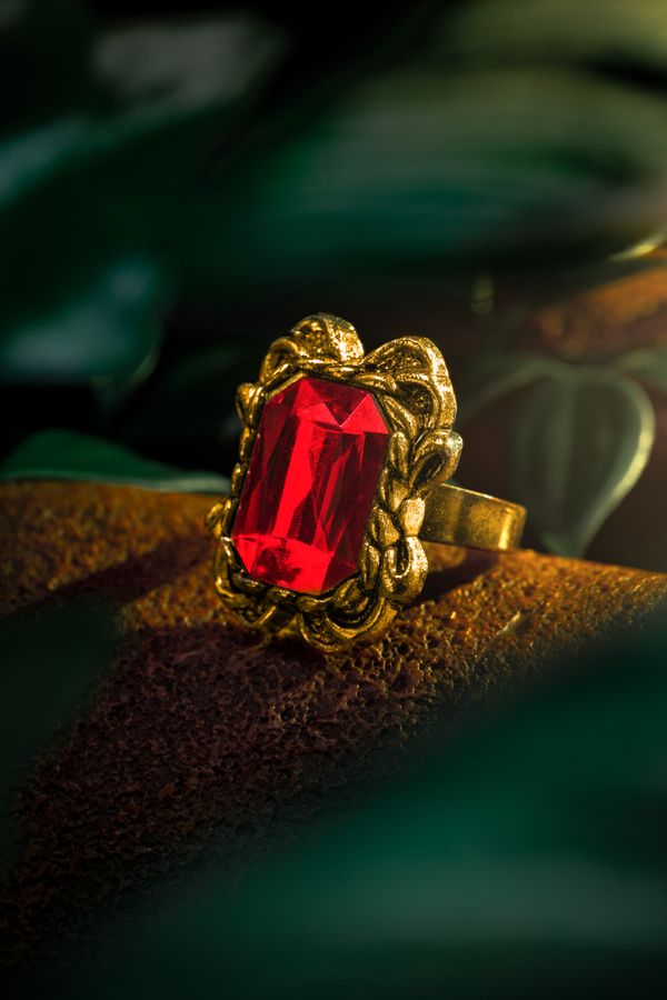 Macro shot of a gold ring with a red gemstone