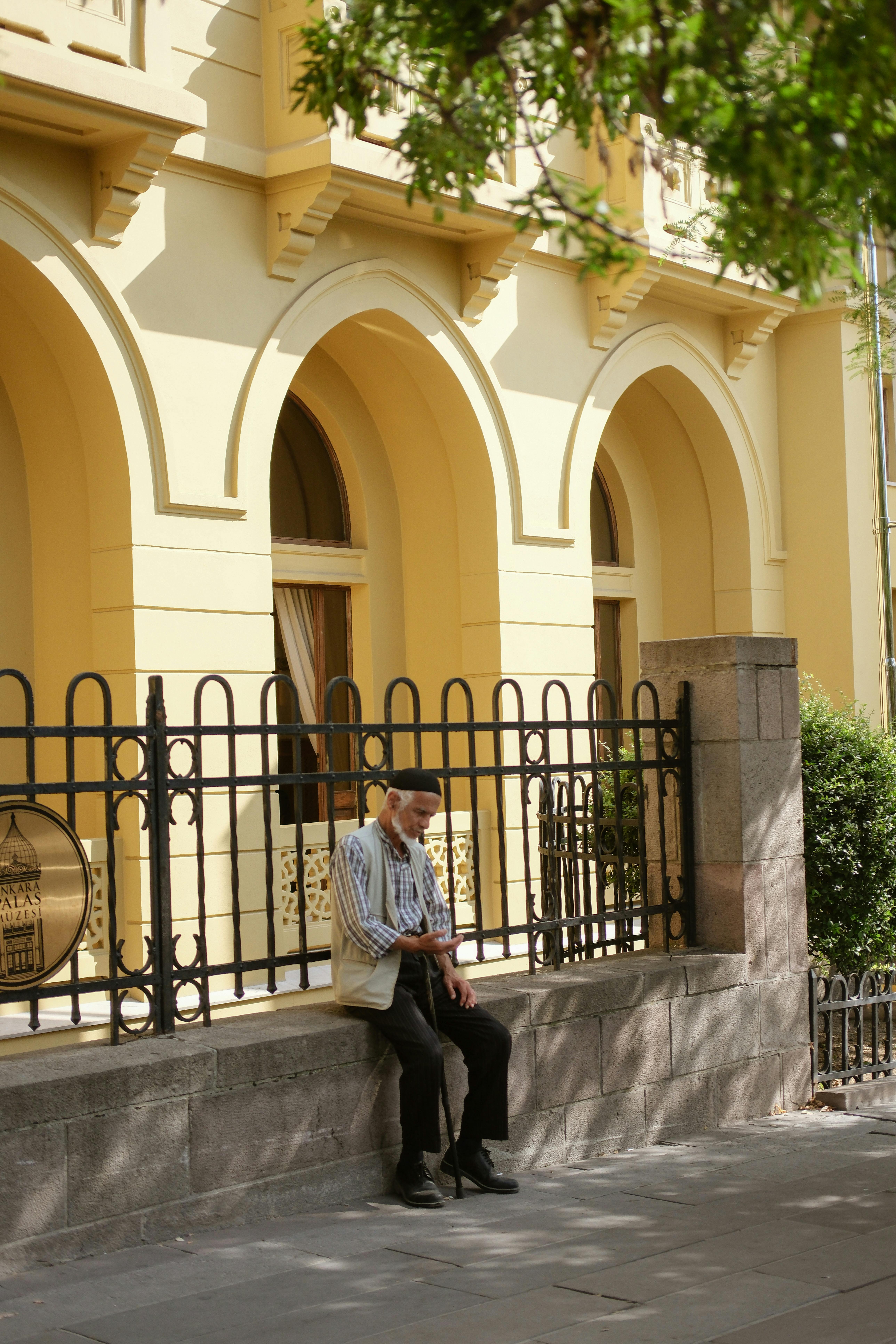 a man sitting on a bench outside of a building