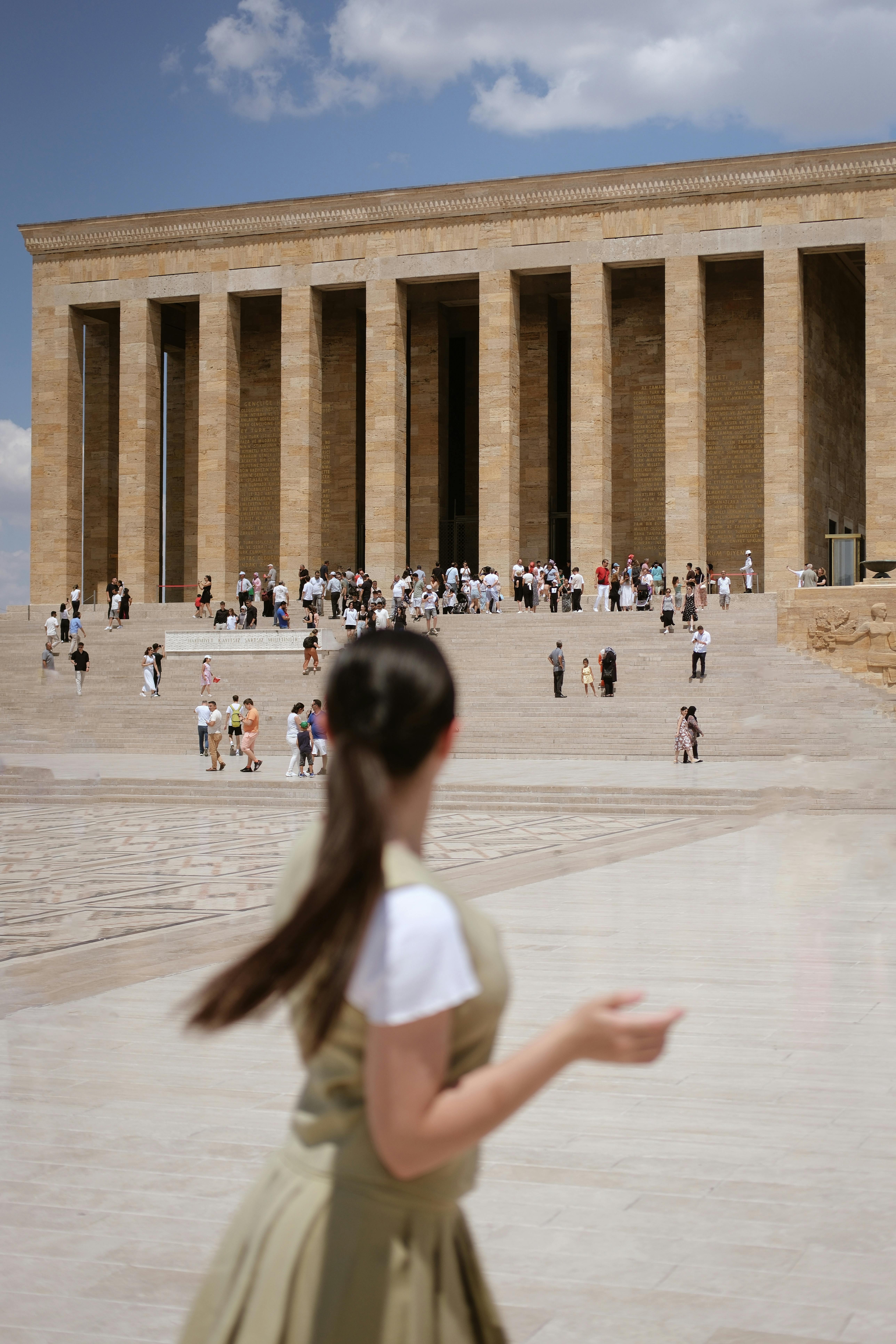 a woman is walking in front of a large building