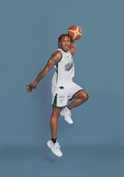 A professional athlete performing a slam dunk during an energetic basketball photo shoot.