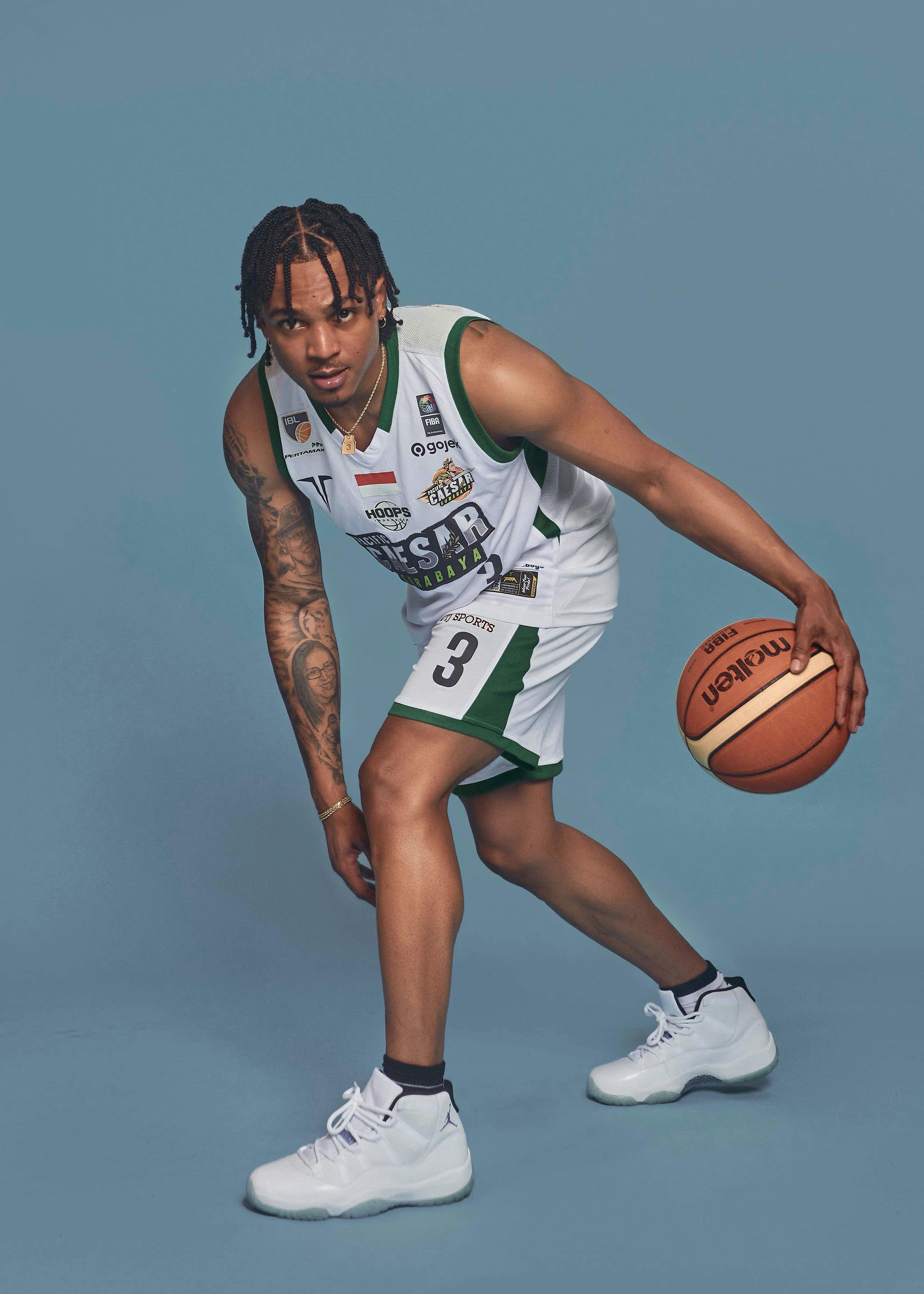 a man in a basketball uniform holding a ball