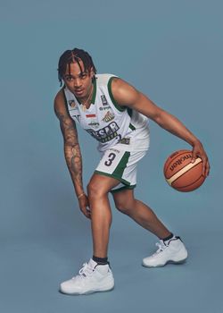 Athletic male in uniform ready to make a basketball move.
