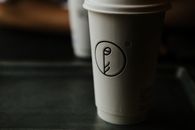 A minimalist coffee cup with unique design in a dark setting, capturing a moody cafe atmosphere.