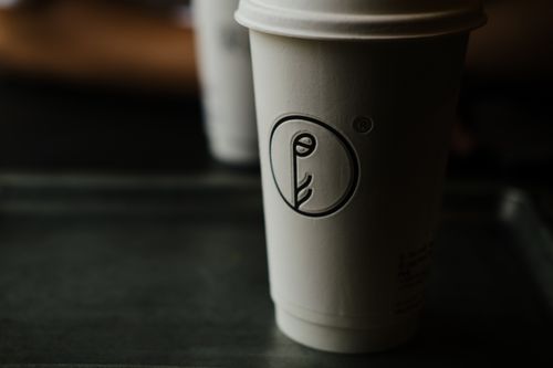 Free A minimalist coffee cup with unique design in a dark setting, capturing a moody cafe atmosphere. Stock Photo