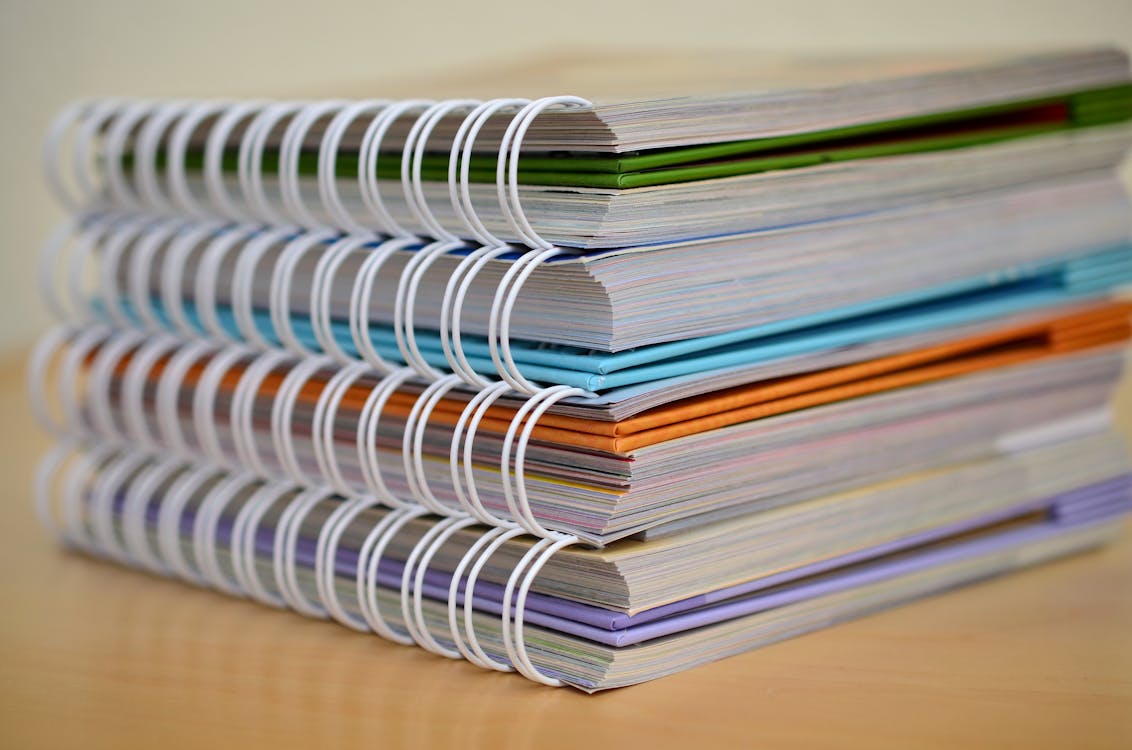 a pile of spiral notebooks. 