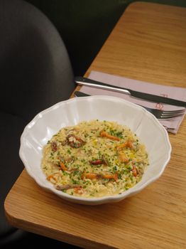 Creamy risotto with mushrooms elegantly served on a wooden table.