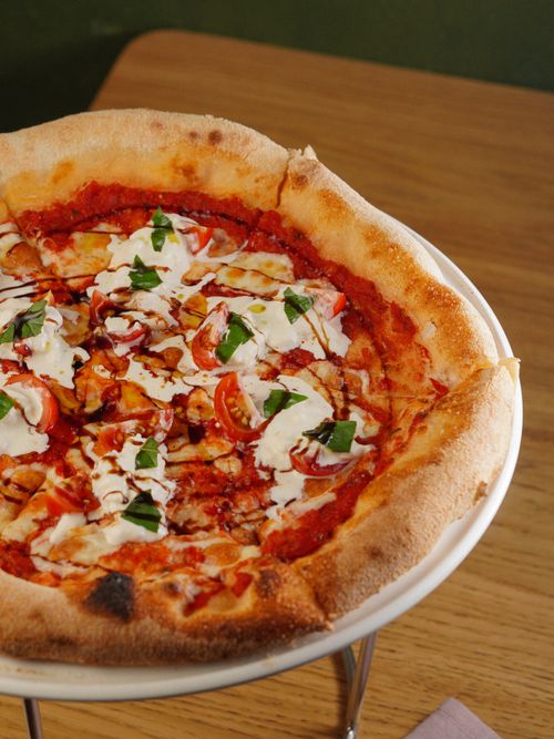 Free Freshly baked Neapolitan pizza topped with cheese and basil, perfect for a savory meal. Stock Photo