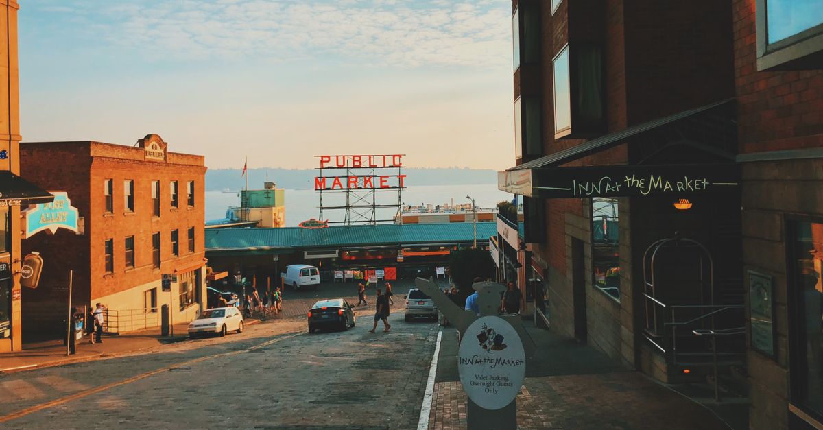A vibrant view of the iconic Pike Place Market in Seattle at sunset, bustling with activity.
