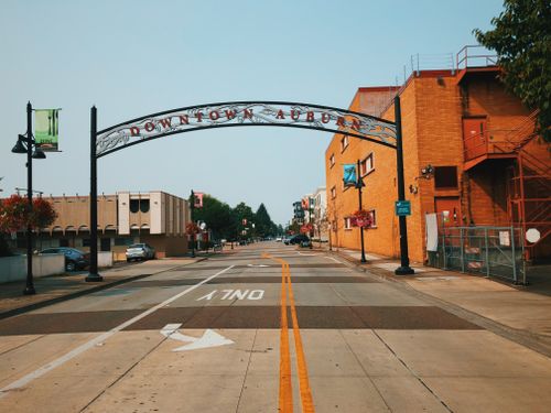 Free View of a street in downtown Auburn featuring an archway and urban architecture. Stock Photo