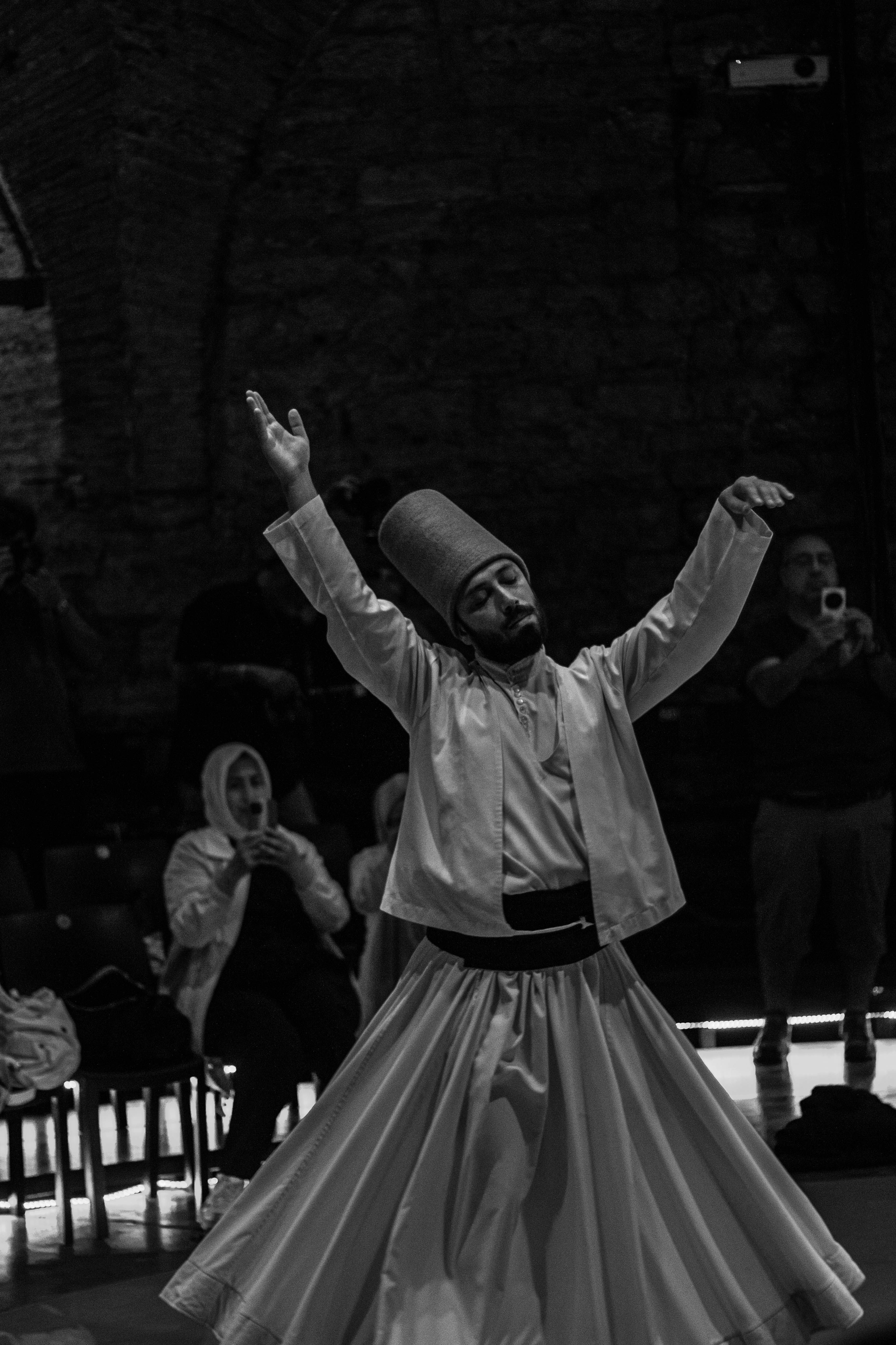 A captivating black and white photo of a traditional Whirling Dervish performing in Istanbul.