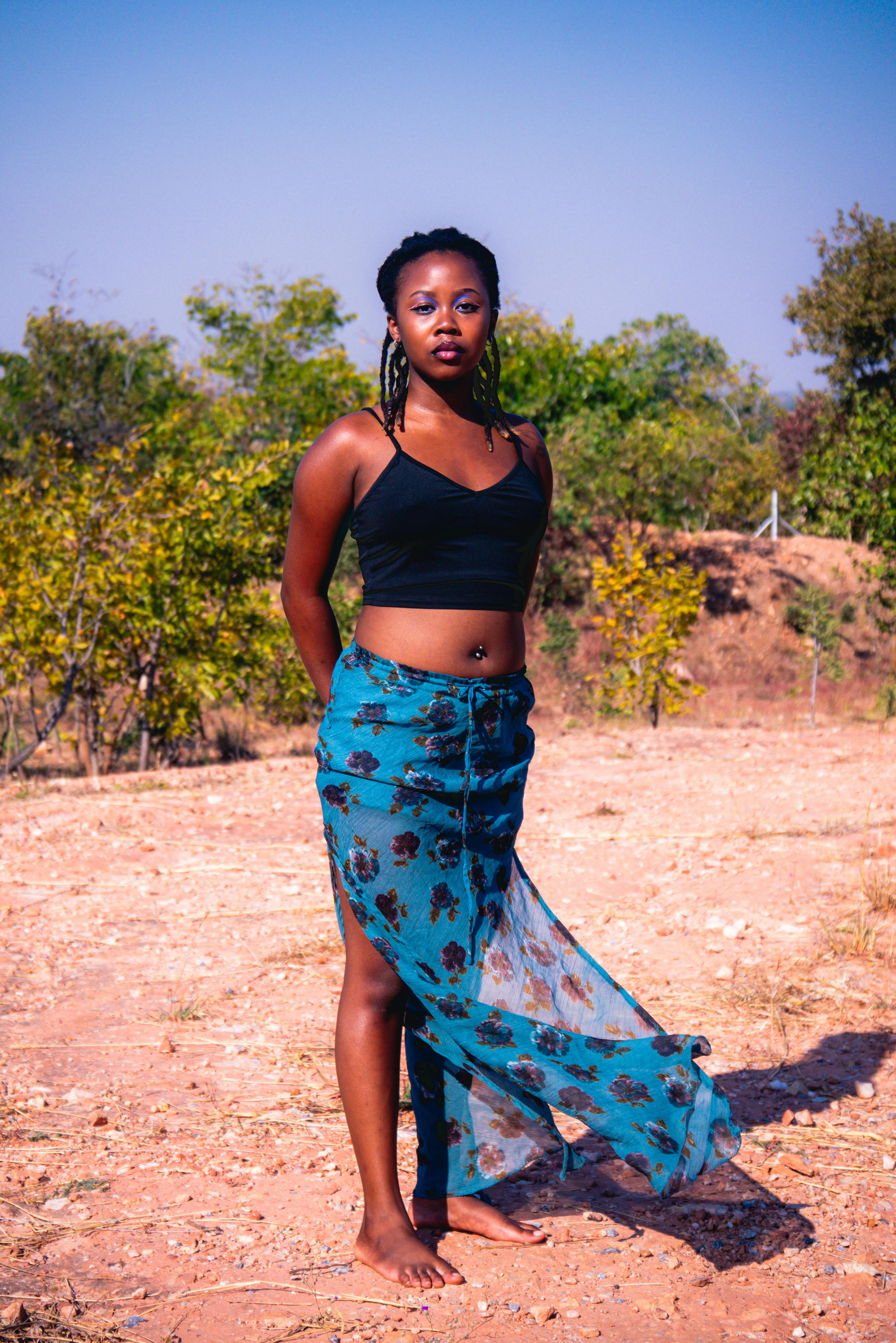 a woman in a skirt standing in the desert