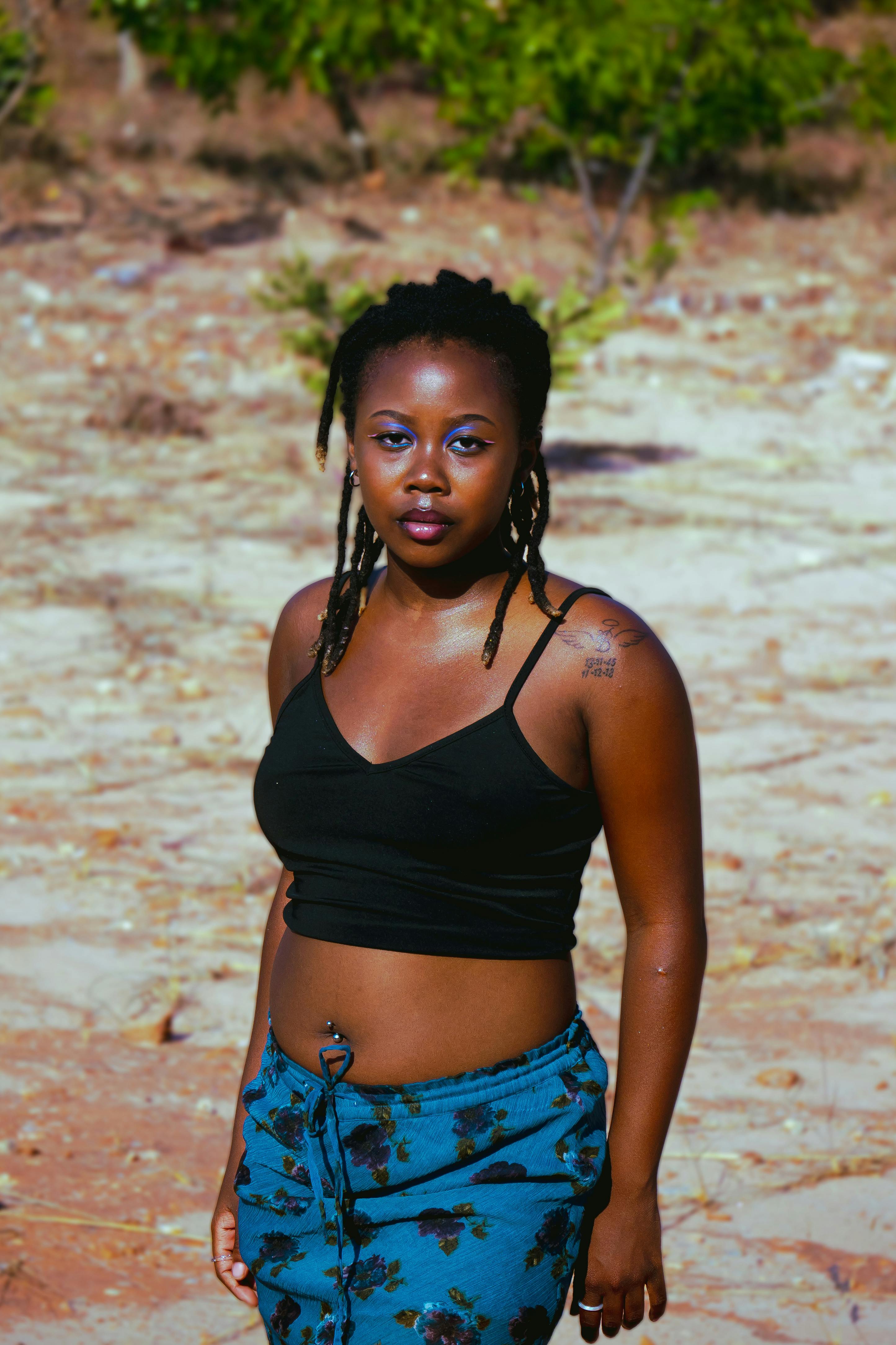 a woman with dreadlocks standing in the desert