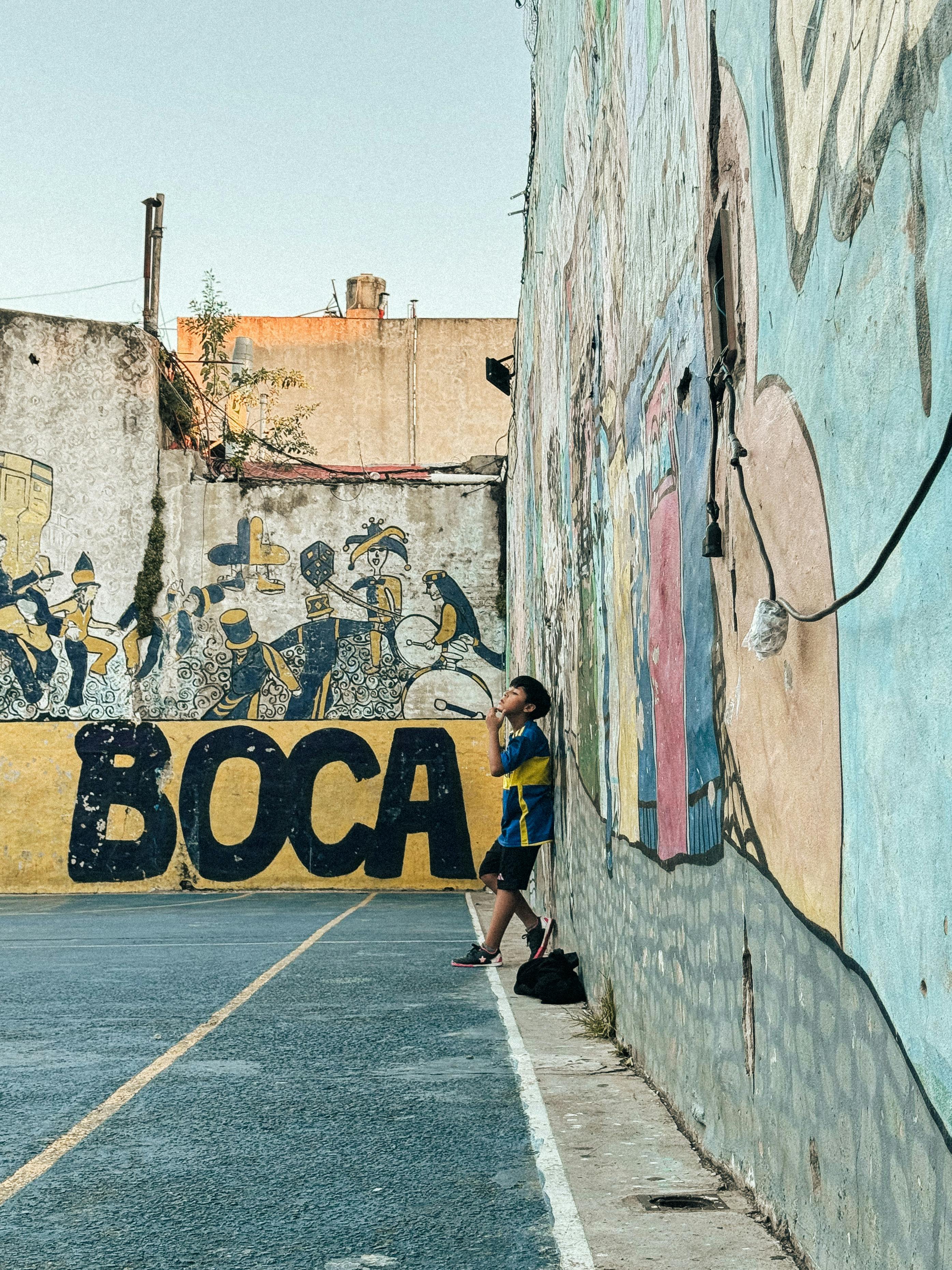 a man is standing in front of a wall with graffiti