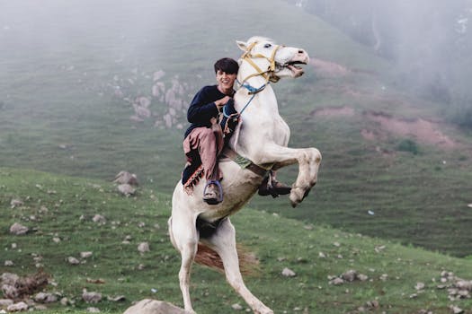 Dynamic shot of a rider on a rearing horse in the misty hills of Naran, Pakistan.