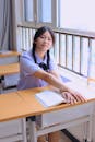 Student Sitting with a Textbook at a School Desk