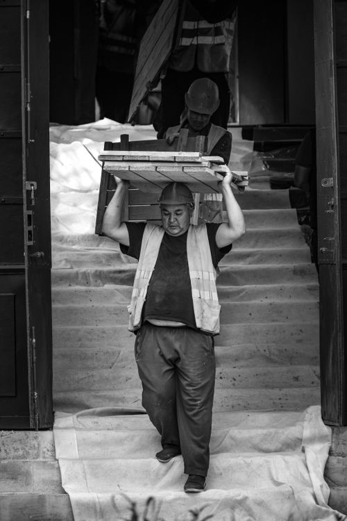 Free Black and white photo of workers carrying materials on stairs at a construction site in Moscow. Stock Photo