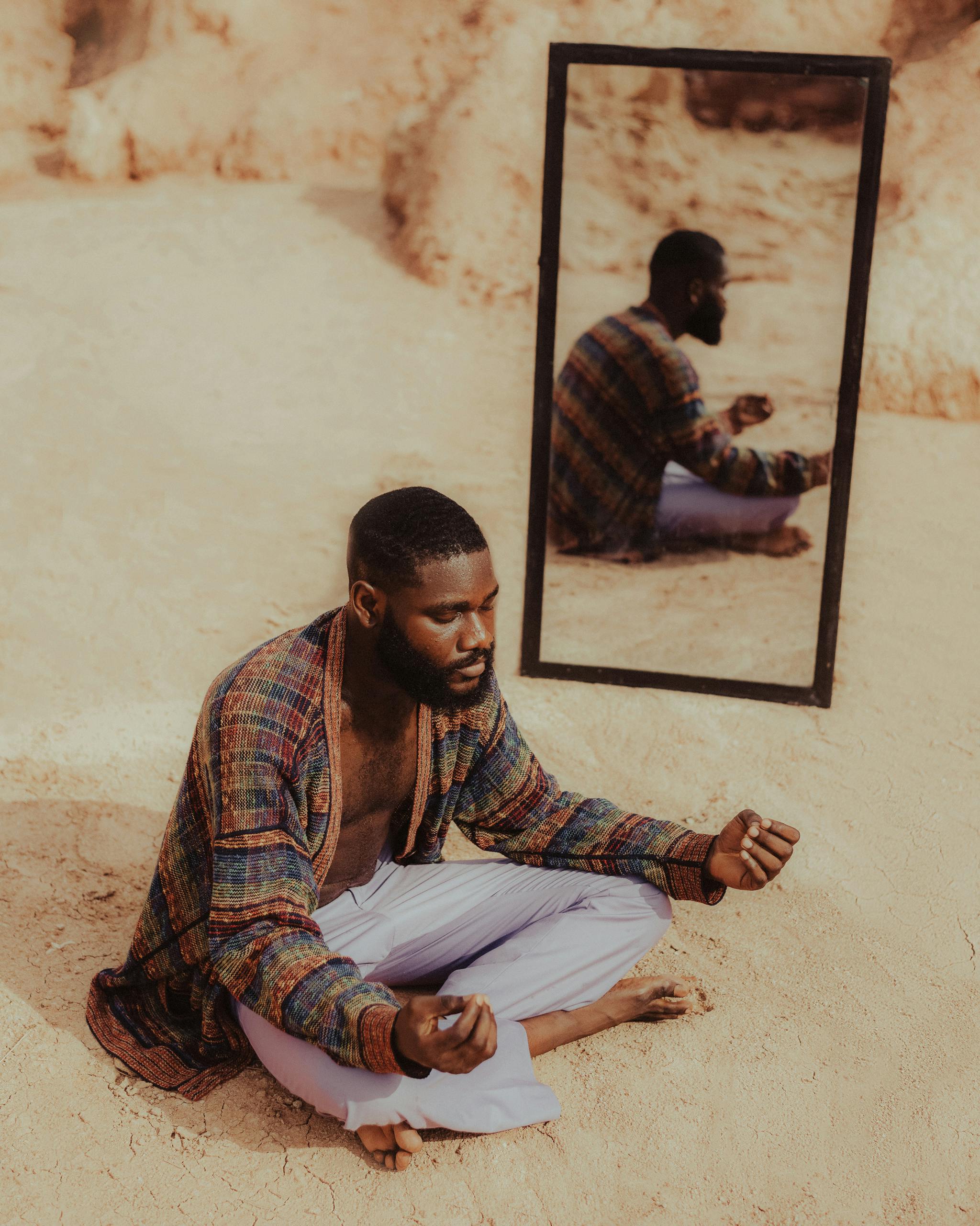 african man with mirror on a desert