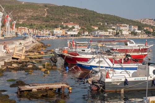 Free Vibrant boats in Foça harbor with scenic views of the Turkish seaside on a sunny day. Stock Photo