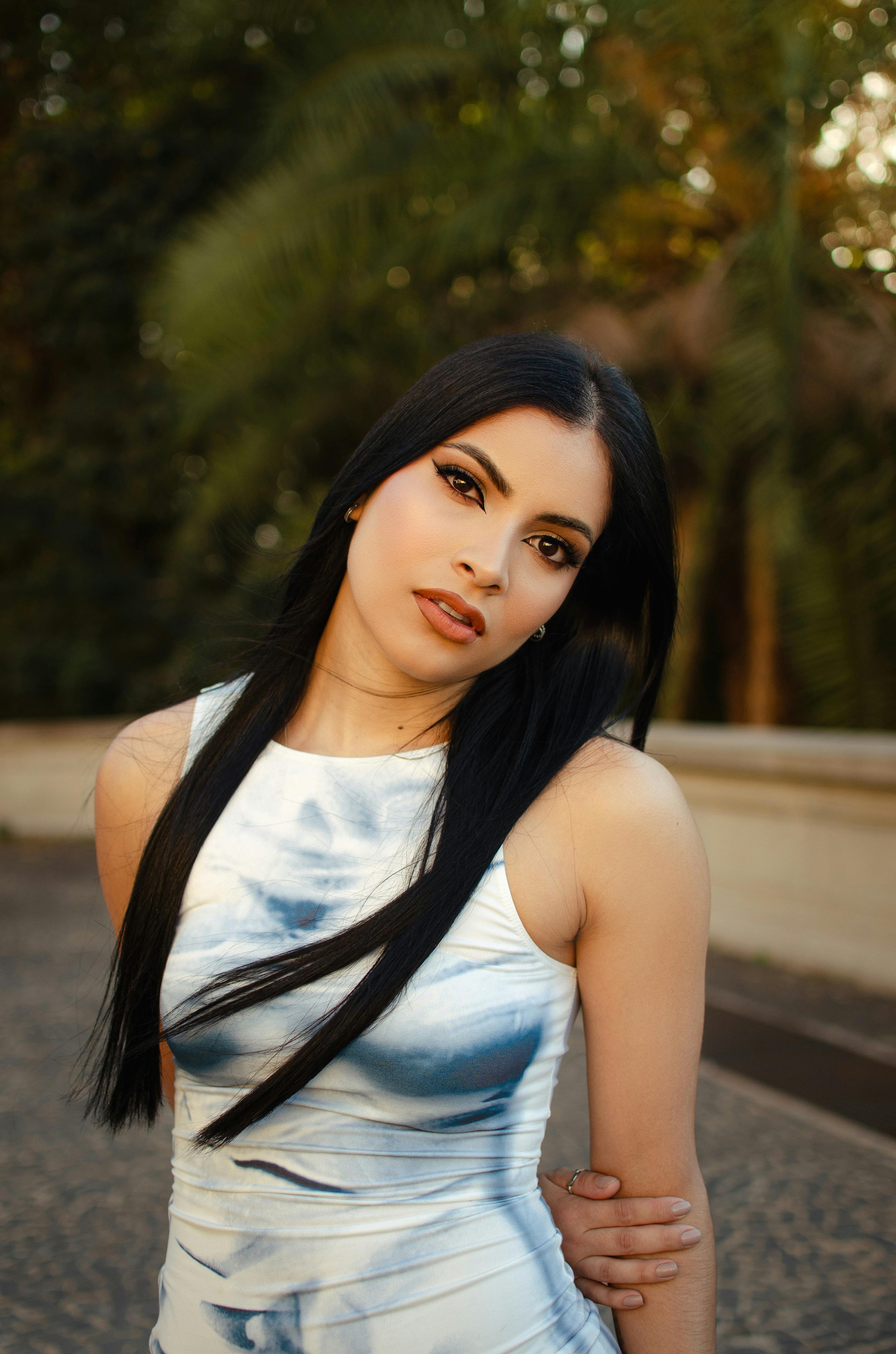 Elegant portrait of a glamorous woman in a stylish outfit enjoying a summer day outdoors.