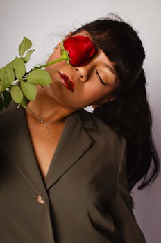 Stylish portrait of a woman holding a red rose. Perfect for fashion and beauty concepts.