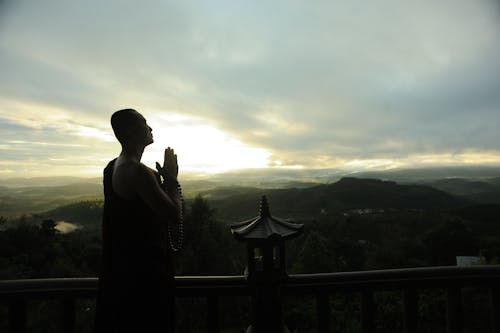 Free Monk Holding Prayer Beads Across Mountain Stock Photo