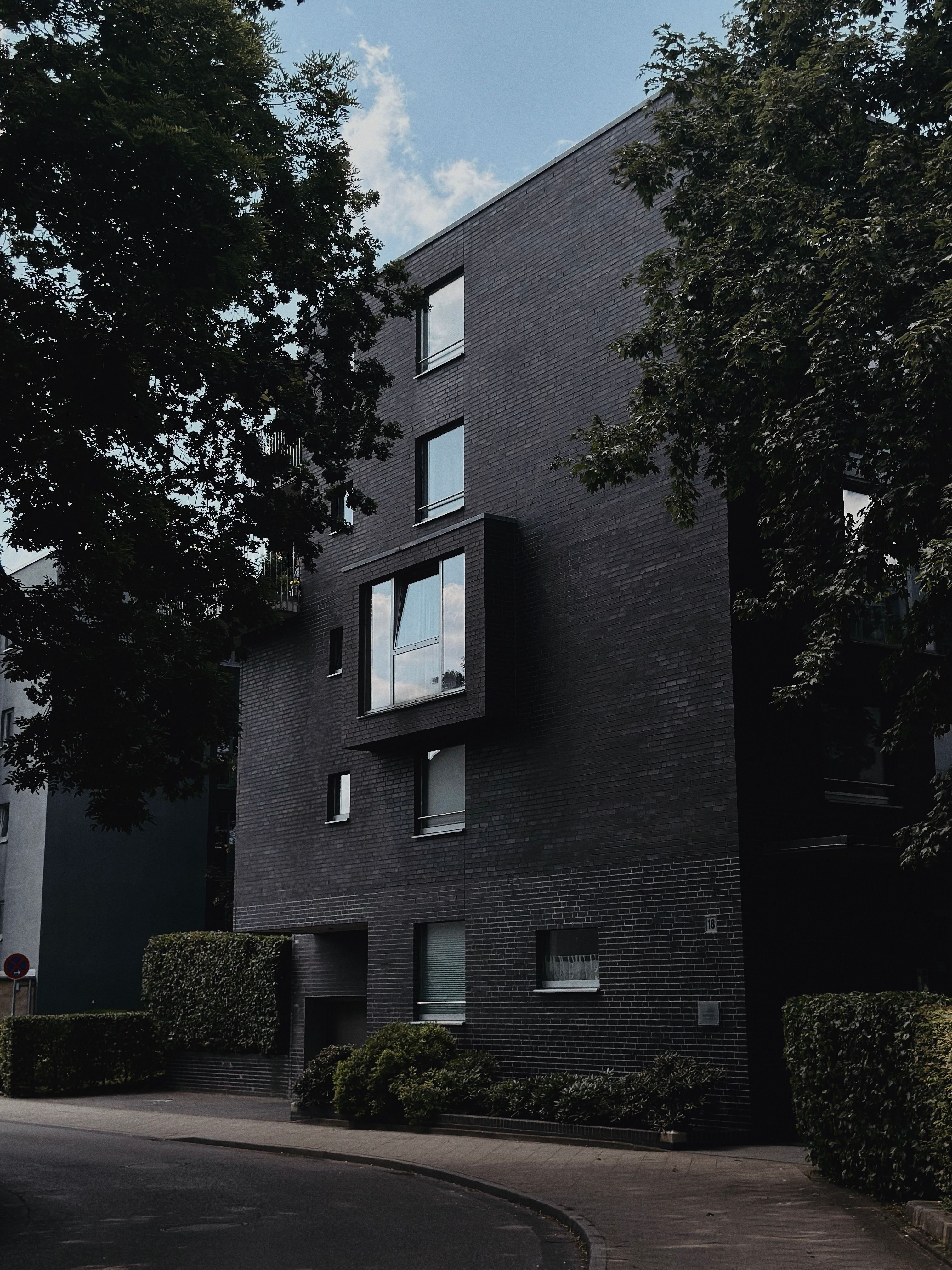 Image showcasing Modern Apartment Building with Dark Brick Exterior · Free Stock Photo