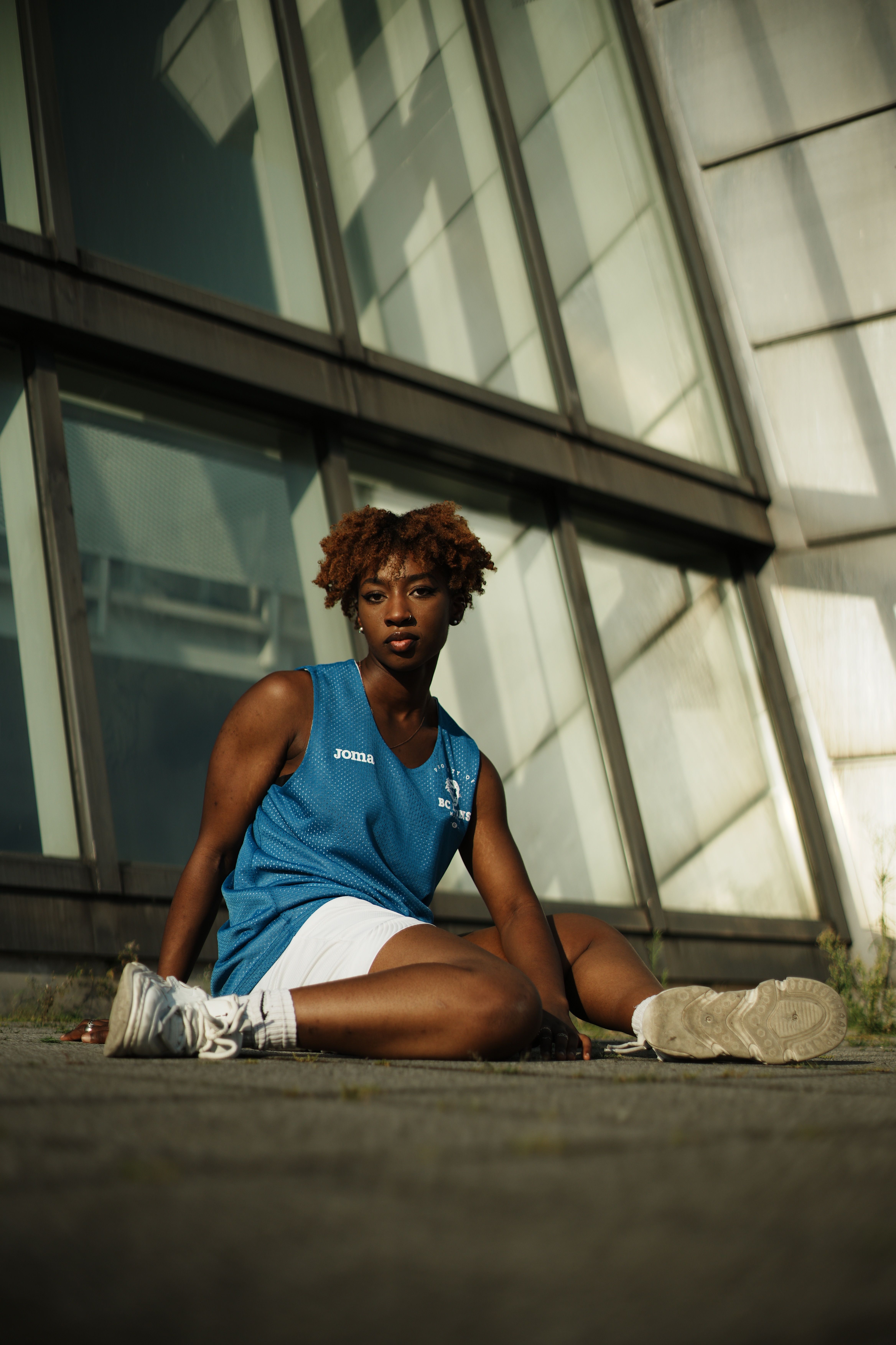 A young woman sitting on the ground in front of a building · Free Stock ...