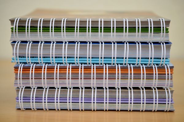 Stack of spiral-bound notebooks on a desk — photo by Pixabay on Pexels
