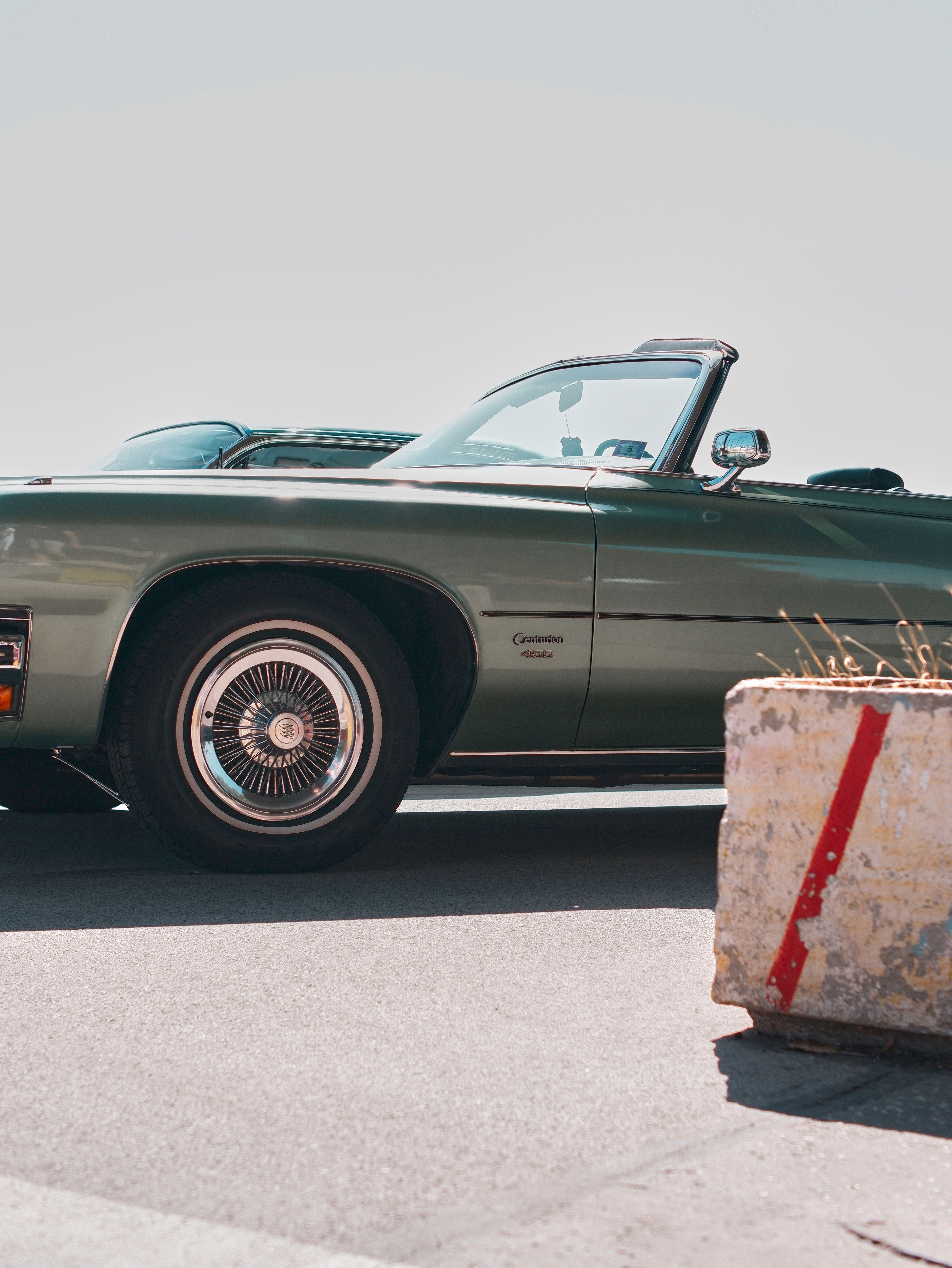 A green car parked on the side of the road · Free Stock Photo
