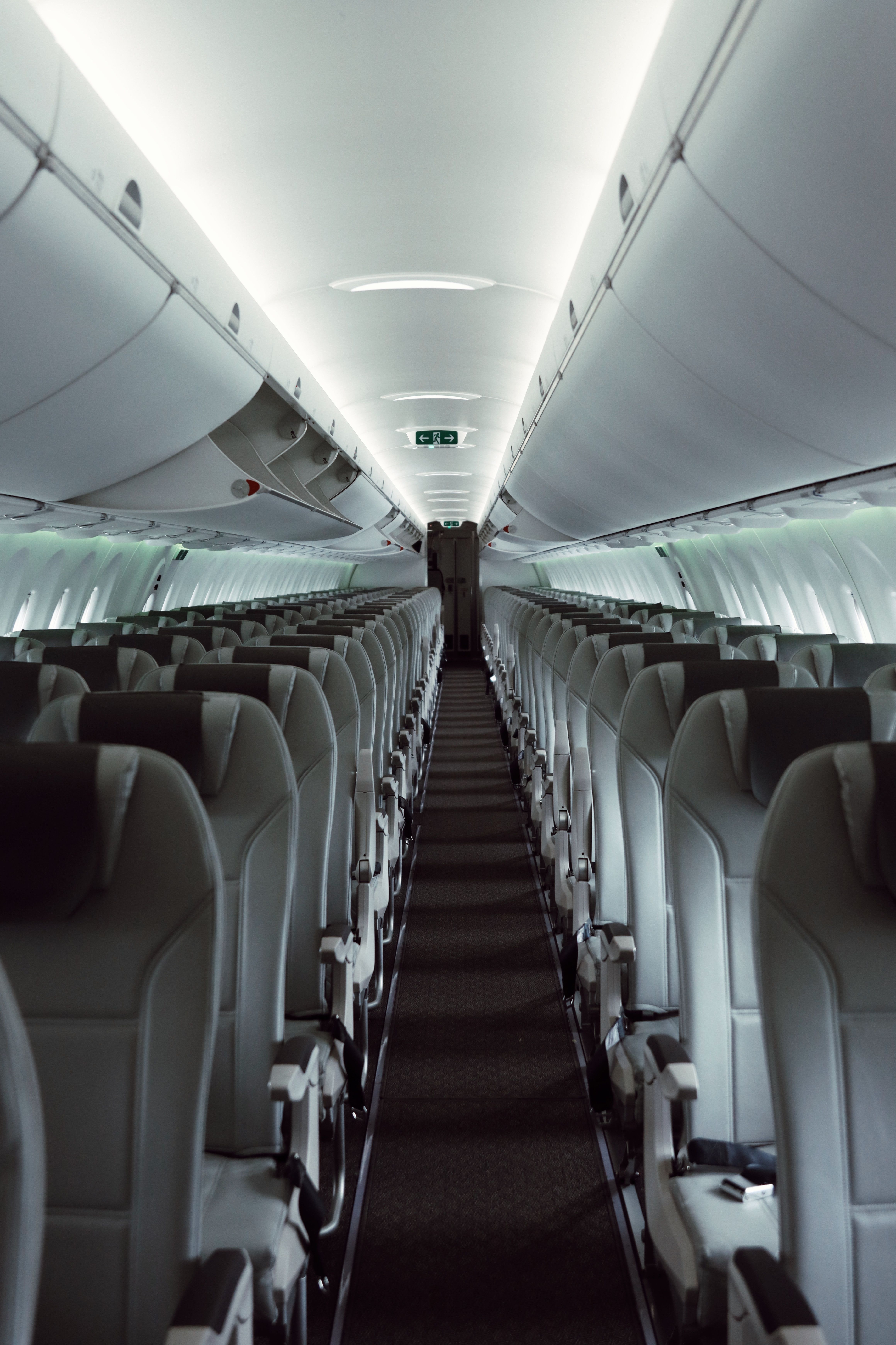 A sleek view of an empty airplane cabin showcasing modern interior design and lighting.