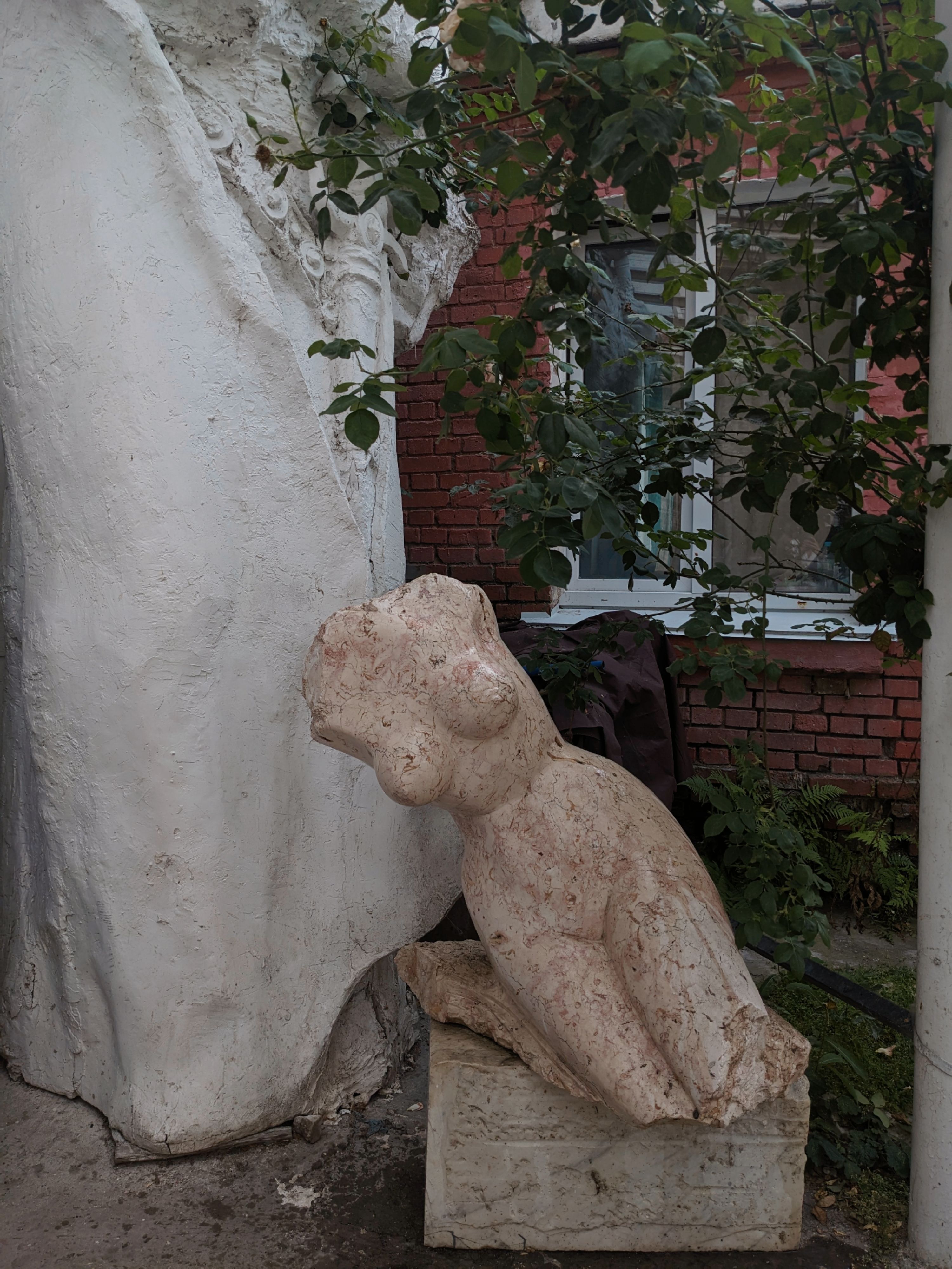 A statue of a woman sitting on a rock · Free Stock Photo