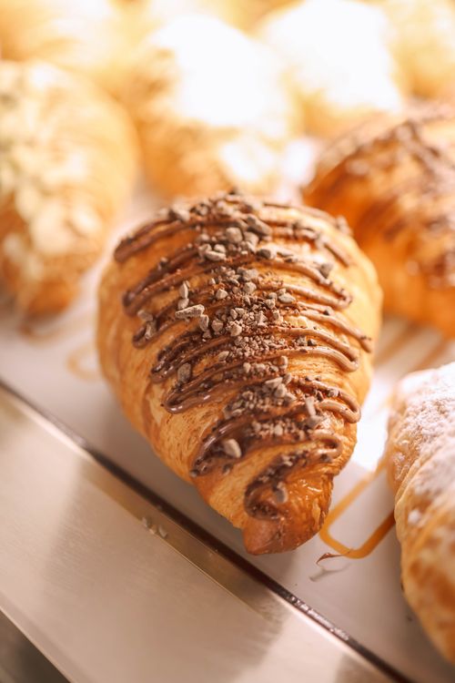 Free Close-up of a chocolate drizzled croissant, perfect for breakfast or indulgence. Stock Photo