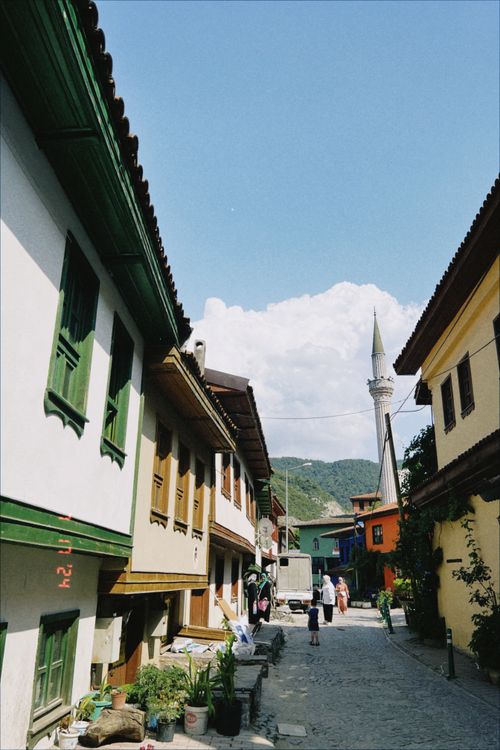 Free Idyllic cobblestone street lined with historic houses and a distant minaret. Stock Photo