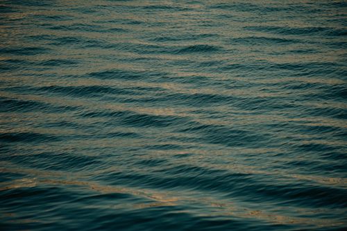 Free A tranquil view of ocean waves with soft ripples reflecting gentle light, evoking calmness. Stock Photo